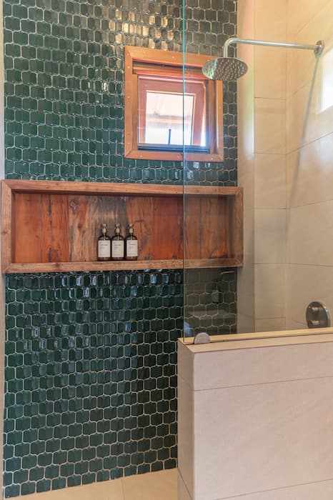 The Residence — shower with green mosaic tile